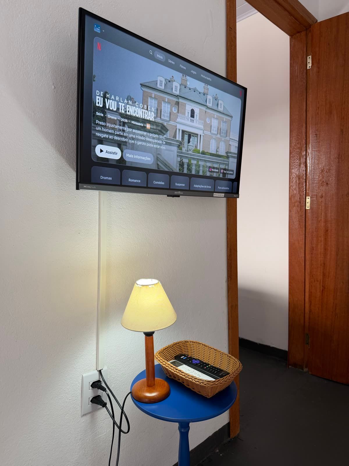 Detalhe da Suíte Estrela: Smart TV e abajur de luz quente