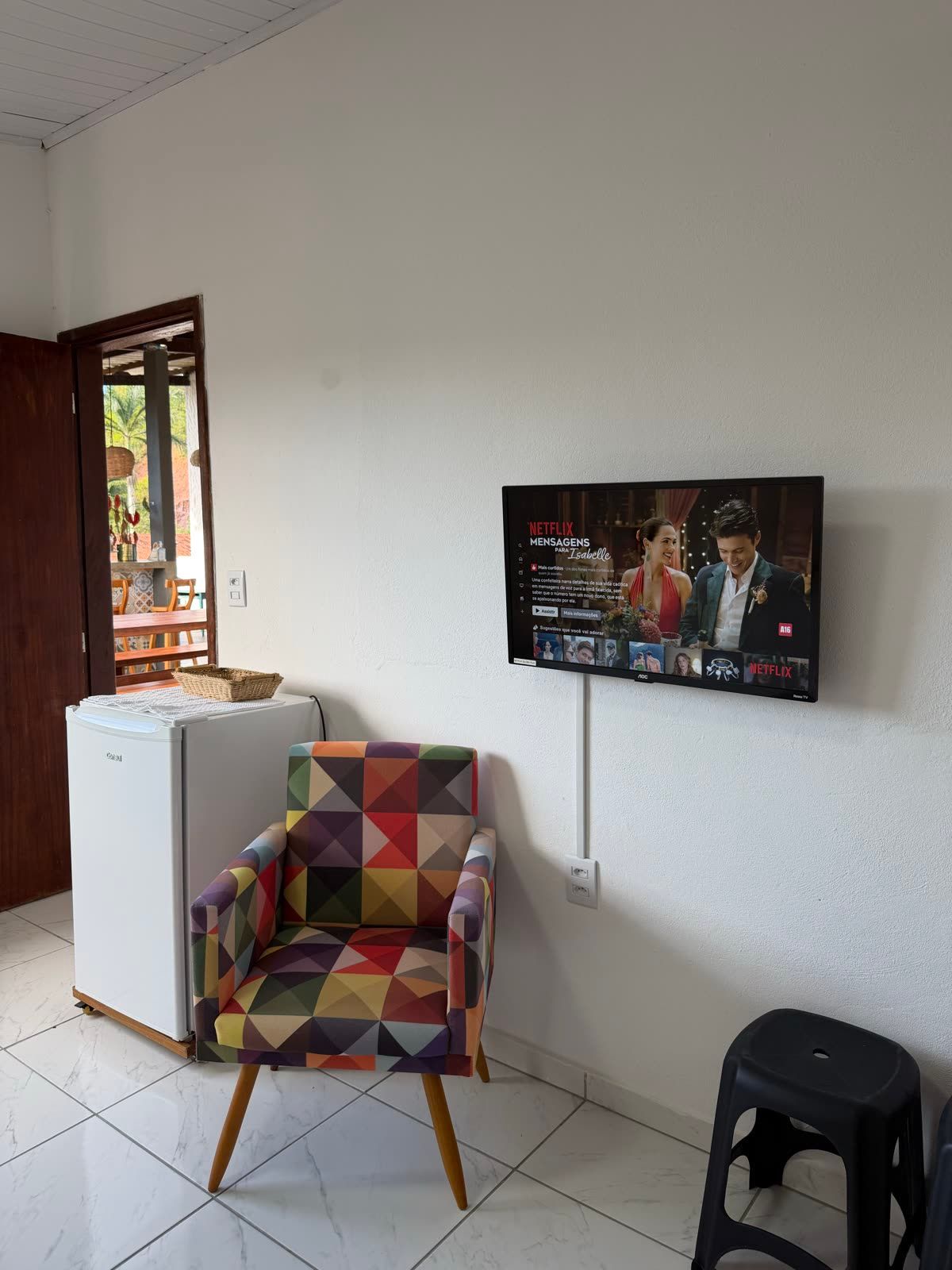 Suíte Mar com poltrona colorida, frigobar e Smart TV