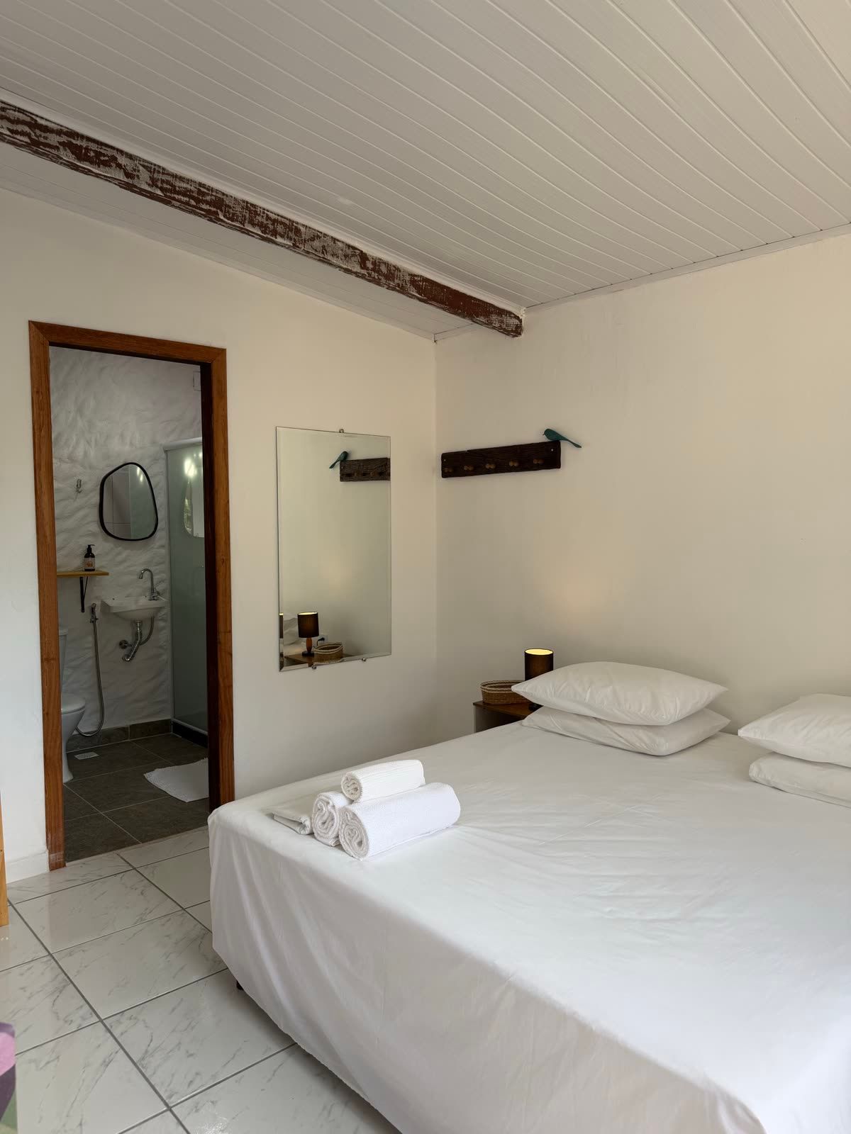 Suíte Mar: cama de casal e acesso ao banheiro privativo